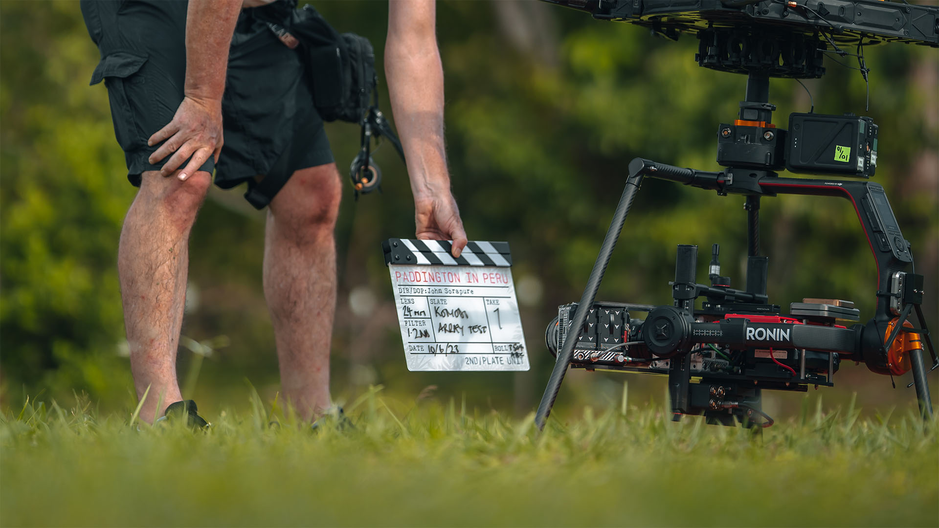 man holding clapperboard in front of drone camera on set
